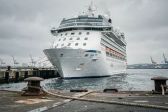Grand paquebot de croisière amarré au port de Calais avec les infrastructures portuaires en premier plan