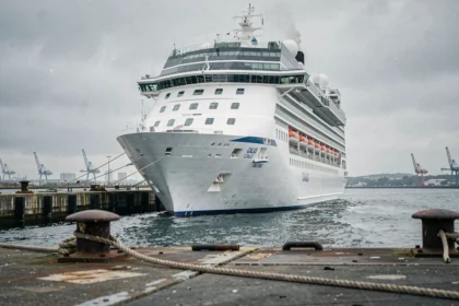 Grand paquebot de croisière amarré au port de Calais avec les infrastructures portuaires en premier plan