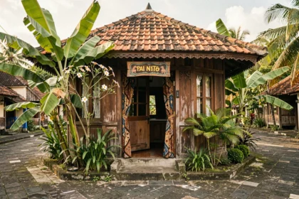 Petite guesthouse balinaise traditionnelle à Padangbai avec façade en bois sculpté et végétation tropicale luxuriante