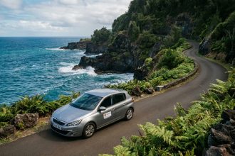 Voiture de location catégorie C sur une route côtière de l'île de la Réunion avec vue sur l'océan Indien